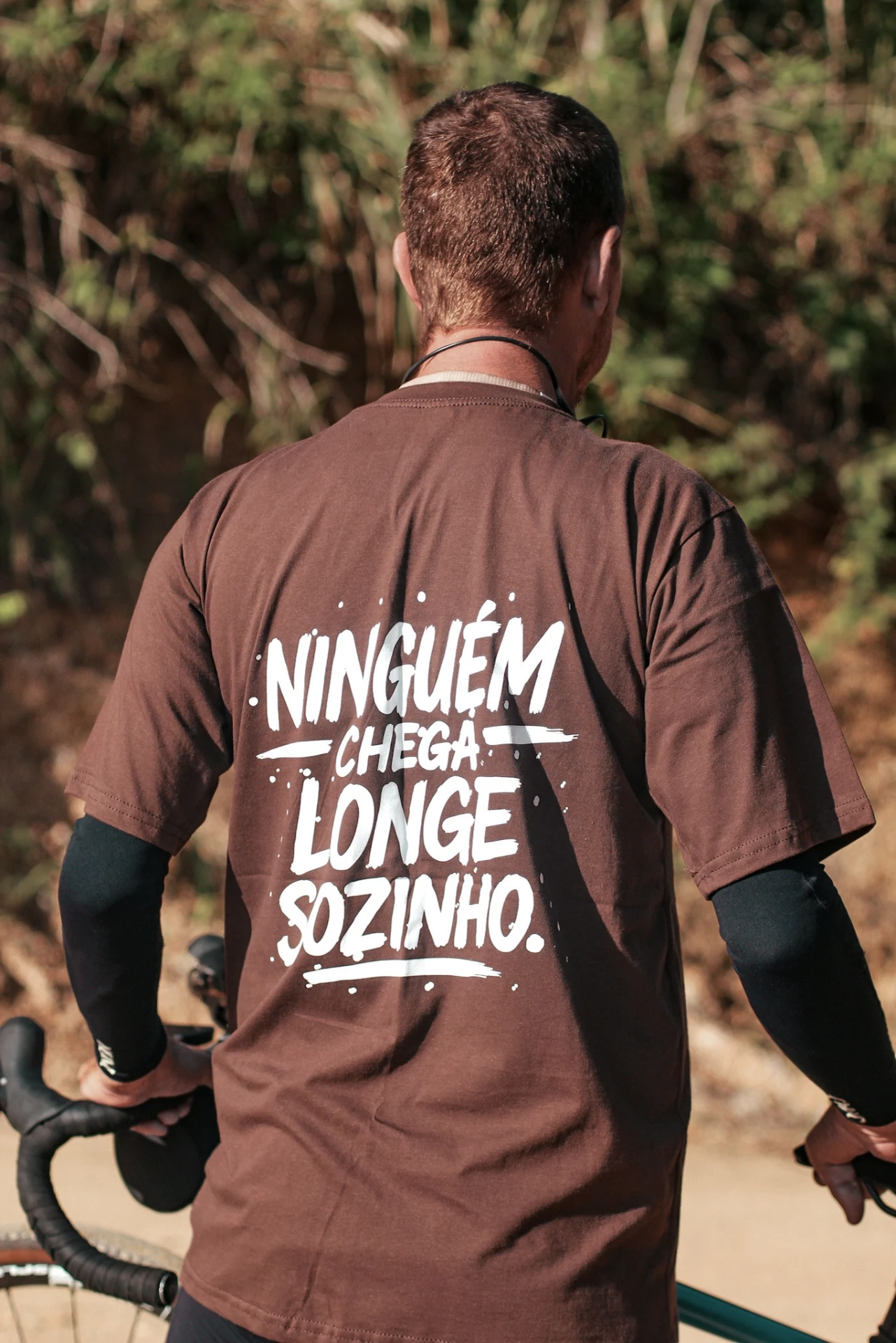 Costas da camisa da Gravel de Pobre com o lettering Ninguém chega longe sozinho